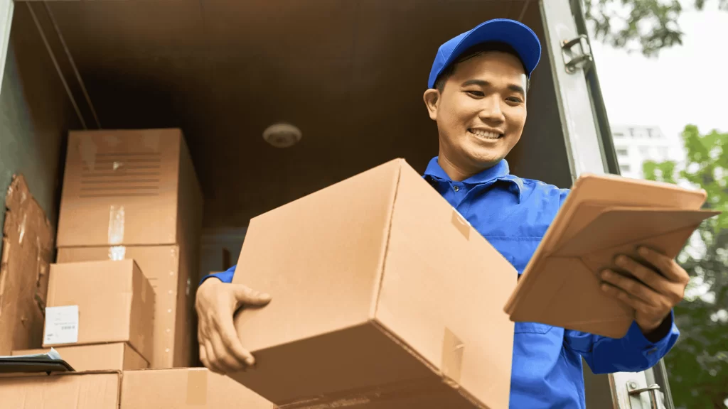Homem vestido de azul segurando uma caixa