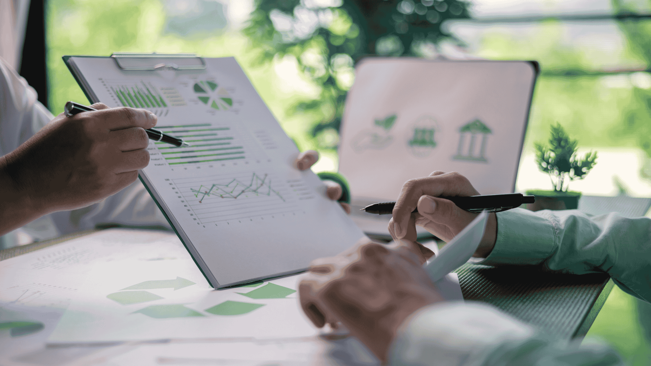 duas mãos segurando prancheta de papel com dashboard analístico de vendas