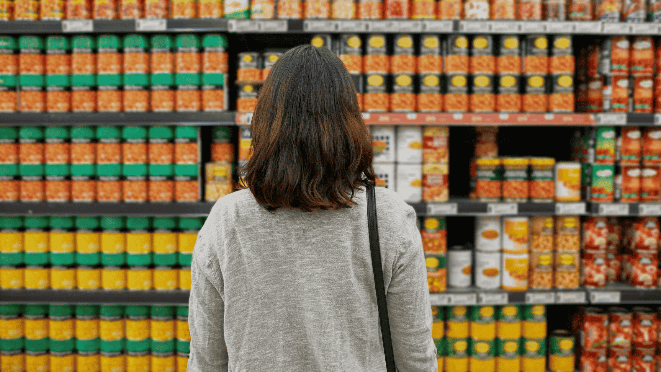 mulher de costas olhando para um ponto de venda no mercado